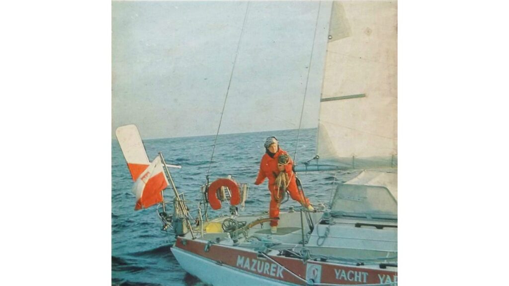 Krystyna Chojnowska-Liskiewicz standing on deck of Mazurek with rigging in the background.