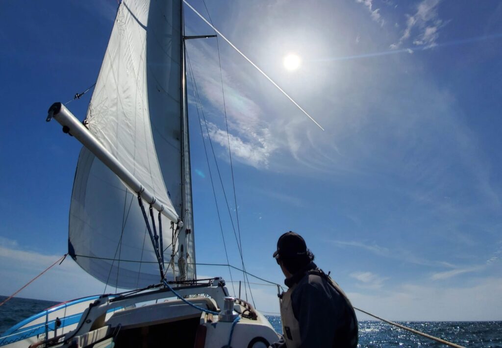 A man looks out to sea on a sailboat