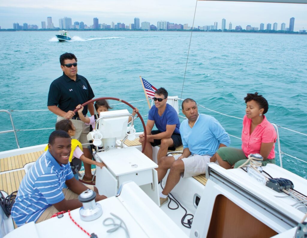 a family on a sailboat with the chicago skyline visible 