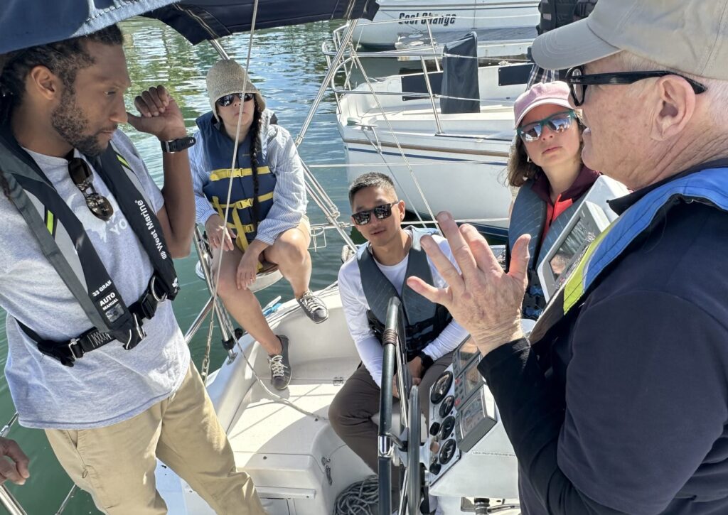 a sailing instructor briefs his students
