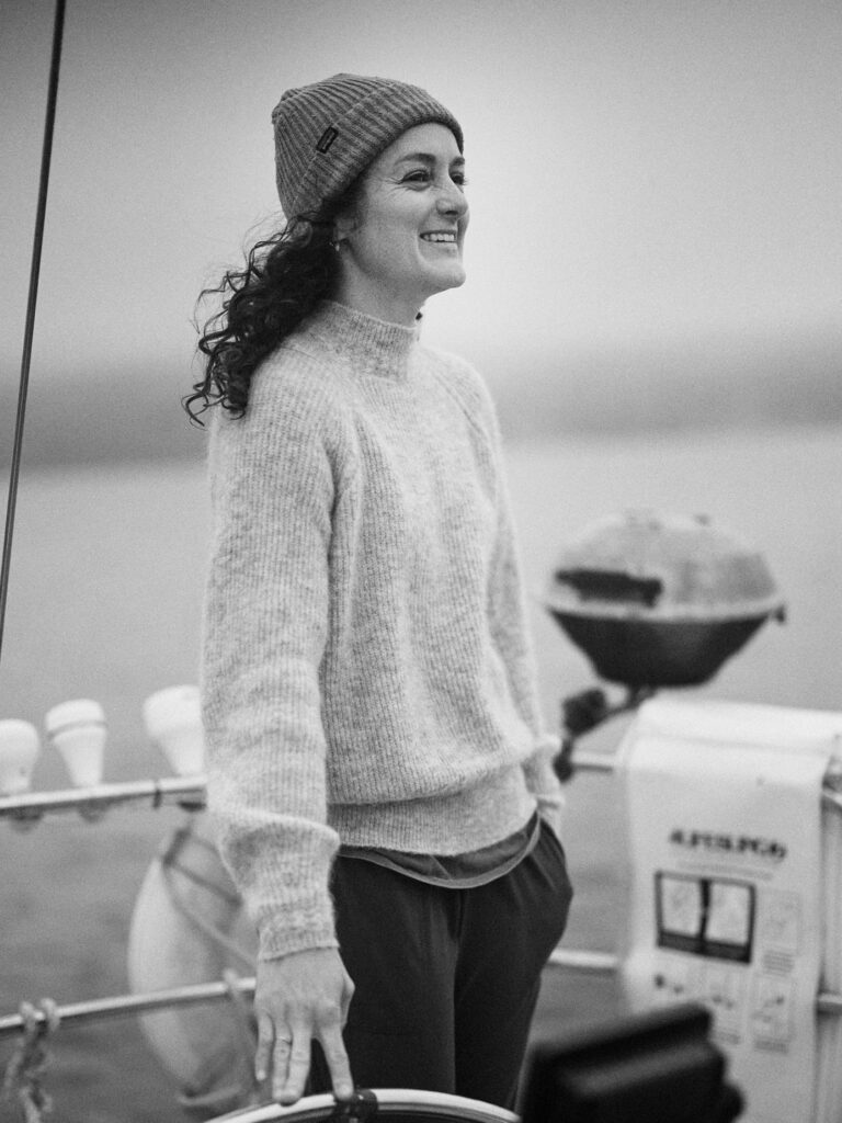 Emma smiling on deck in black and white