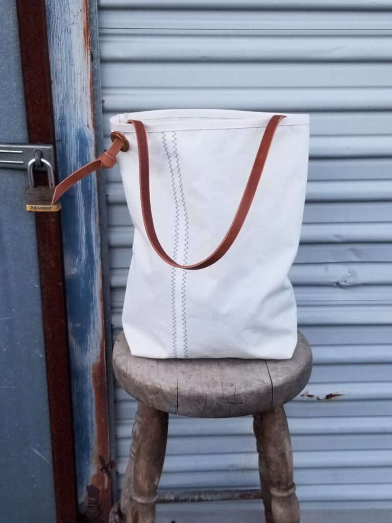 Large tote with rope handles on metal door